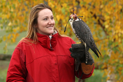 Smiling woman looking at bird in park