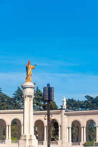 Low angle view of statue against blue sky