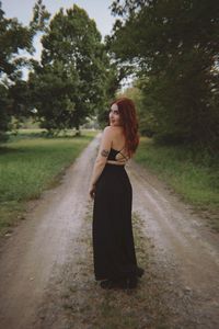 Full length of woman standing on dirt road