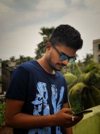 Young man using mobile phone outdoors