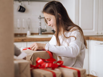 Young woman using mobile phone while sitting at home