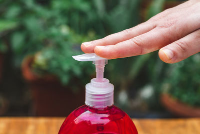 Close-up of hand holding red bottle