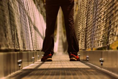 Low section of man standing on a bridge