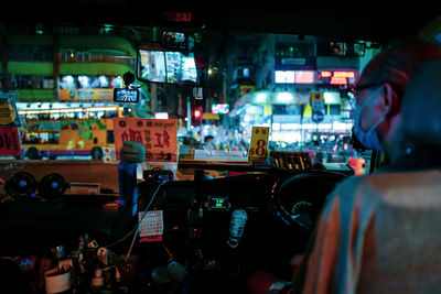 Rear view of people at illuminated market stall