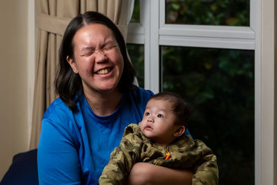 Portrait of smiling boy looking through window