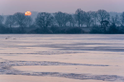 Scenic view of snow covered field against sky
