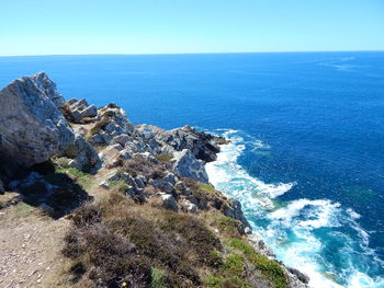 Scenic view of sea seen from cliff against sky