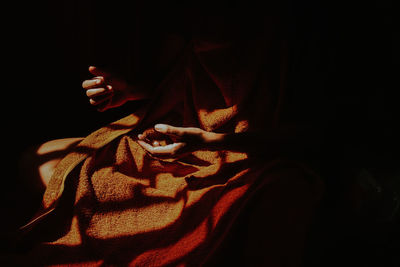 Close-up of woman hand against black background