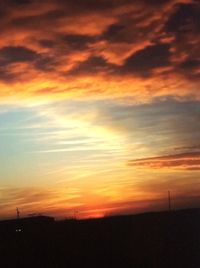 Scenic view of silhouette landscape against orange sky