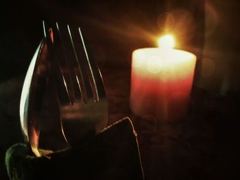 Close-up of lit candle in dark room