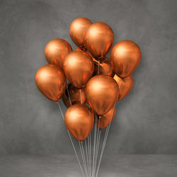 Close-up of balloons on table against wall