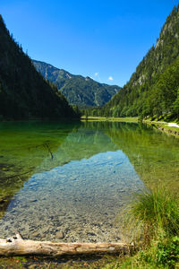 Scenic view of lake and mountains against blue sky