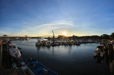 Sailboats in harbor at sunset