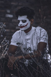 Man with face paint crouching on land