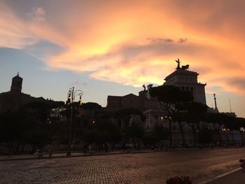 Buildings against sunset sky
