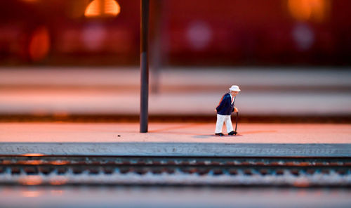 Close-up of model toy train set man on train station platform