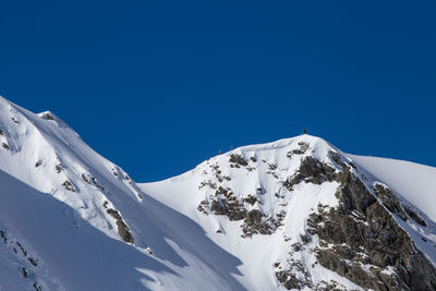 Scenic view of snowcapped mountains against clear blue sky