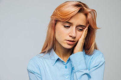 Close-up of thoughtful young woman over white background