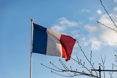 Low angle view of flag against blue sky