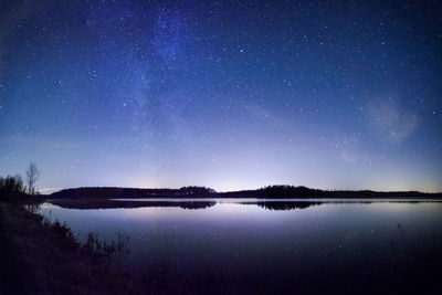 Scenic view of lake against sky at night