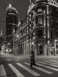 Fashionable woman crossing the street at night