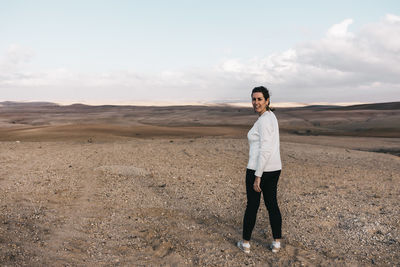 Full length of woman standing on land against sky