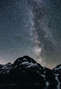 Scenic view of snowcapped mountains against sky at night