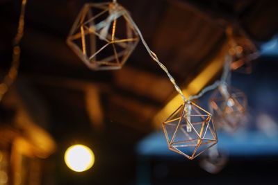 Low angle view of illuminated lighting equipment hanging on ceiling