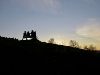 Silhouette people standing on field against sky