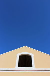 Low angle view of building against clear blue sky