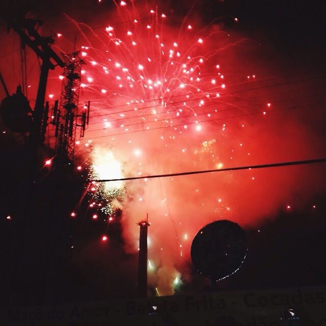 LOW ANGLE VIEW OF FIREWORK DISPLAY IN CITY AT NIGHT