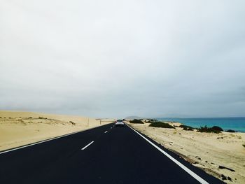 Long empty road along calm sea