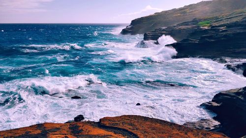 Scenic view of rocks in sea against sky