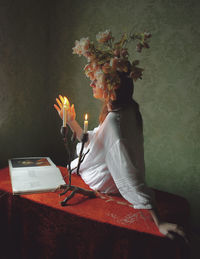 Rear view of woman sitting on table