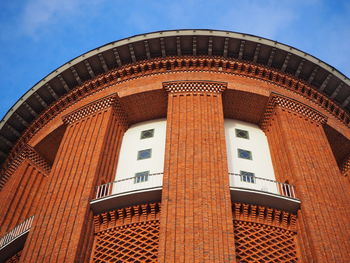 Low angle view of historical water tower building against blue sky