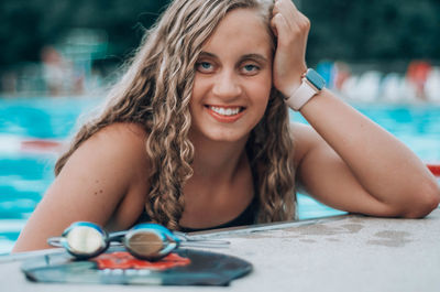 Portrait of beautiful young woman in swimming pool