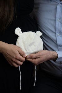 Midsection of couple holding baby clothing