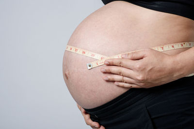 Midsection of woman against white background