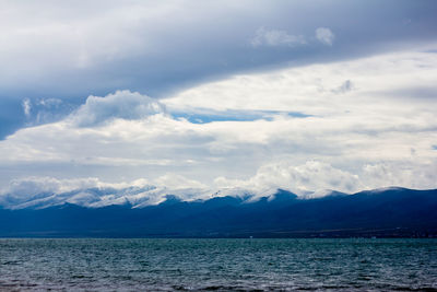 Scenic view of sea and mountains against sky