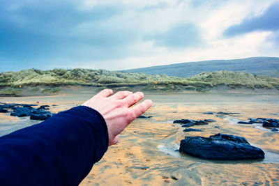 Midsection of person hand on beach