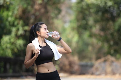 Full length of a beautiful young woman drinking water