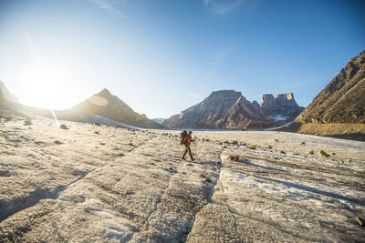 Backpacker exploring large glacier and mountains on baffin island.