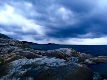 Rock formations in sea against sky