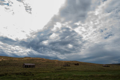 Scenic view of ghost town building in field against sky