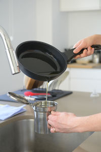 Midsection of person preparing food in kitchen at home