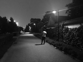 Woman walking on road at night