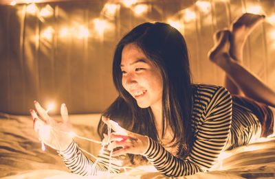 Close-up of young woman using mobile phone at night