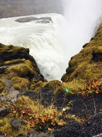 Scenic view of waterfall by rocky mountains