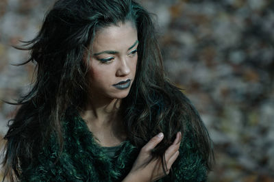 High angle view of serious young woman looking away while standing outdoors