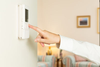 Midsection of person holding umbrella at home